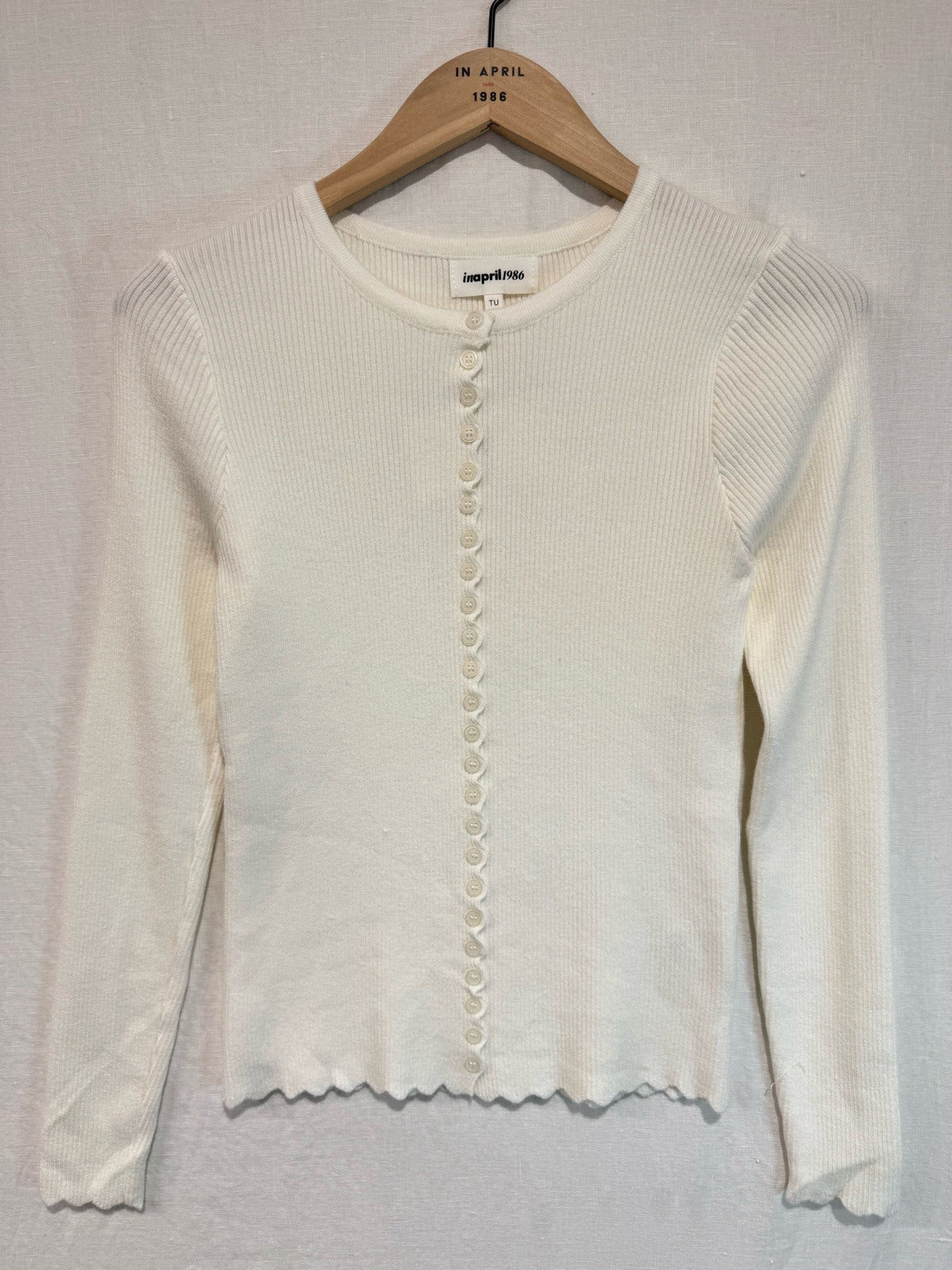 Rippstricktop Mira in Creme – Produktansicht mit gewellten Kanten und dekorativer Mini-Knopfleiste