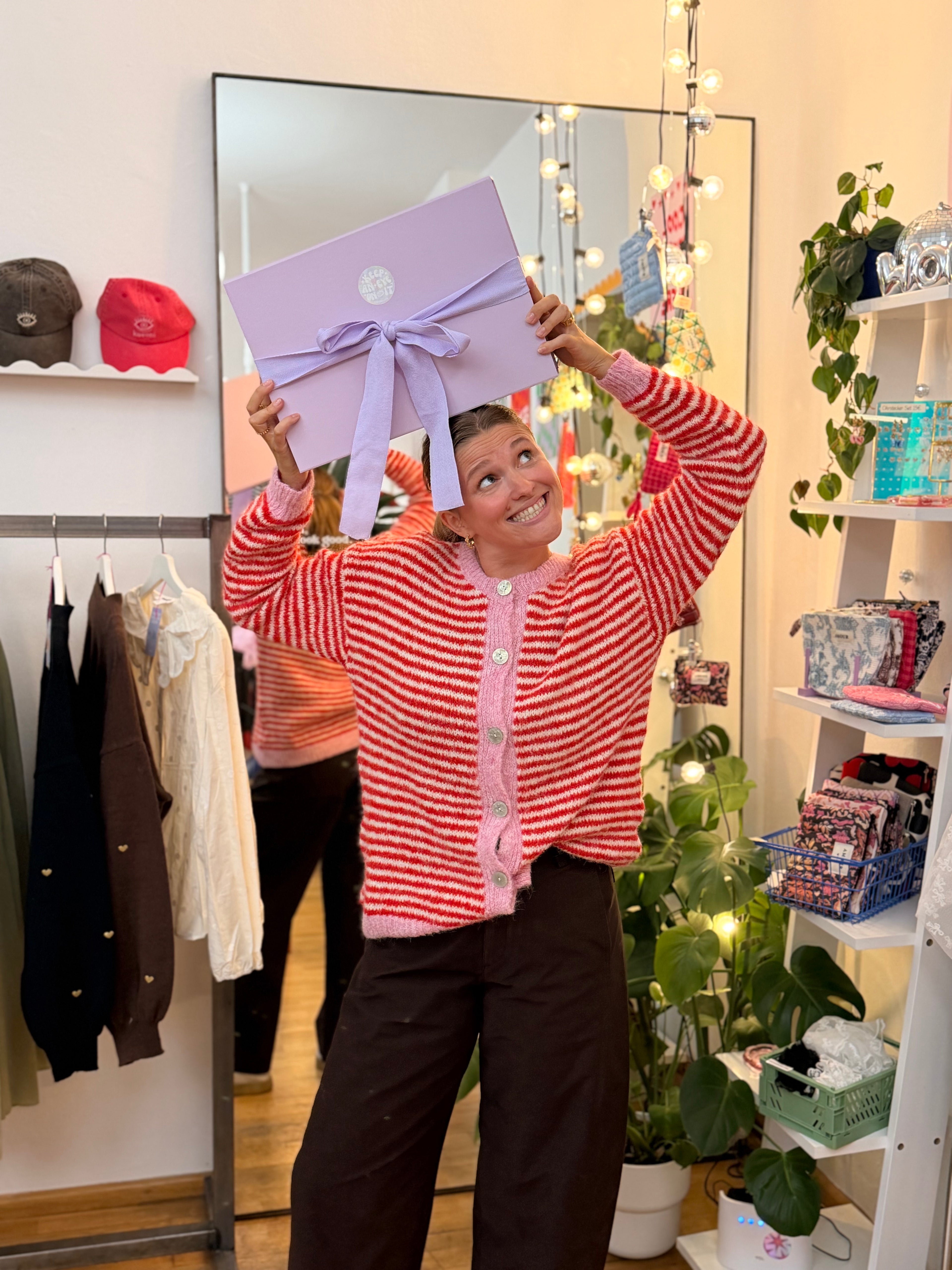 Frau hält den fliederfarbenen KAEONI Adventskalender 2026 im KAEONI Store