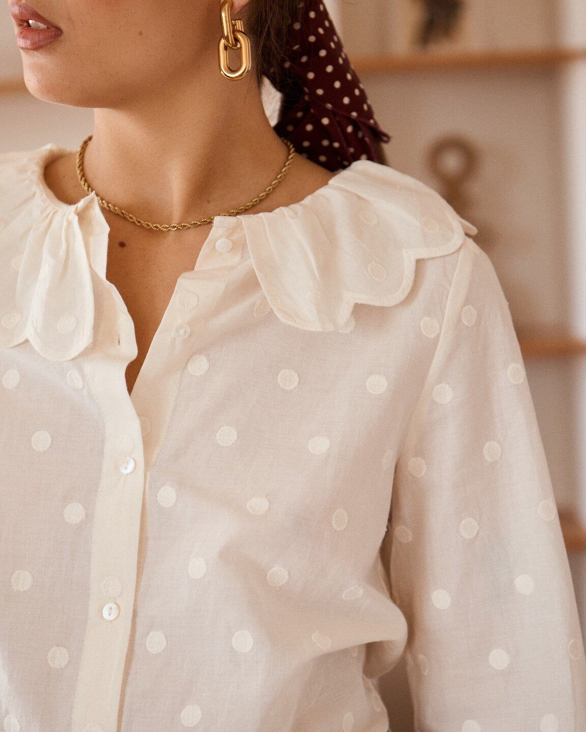 Gestickte Punkte und gewellter Kragen der cremefarbenen Bluse Fleur